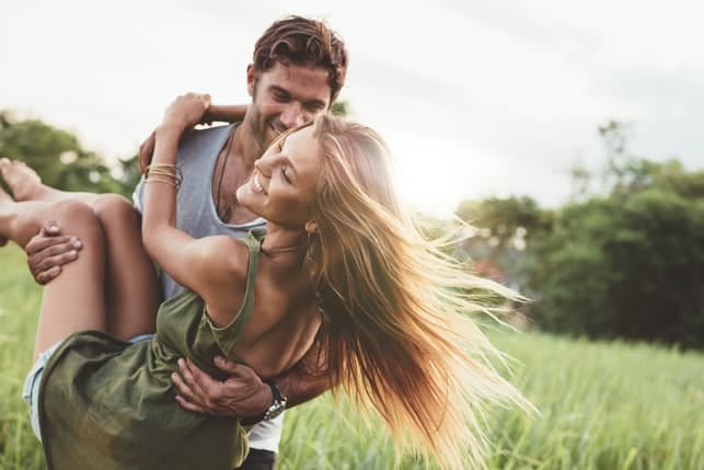 a young couple walking and having fun in the field