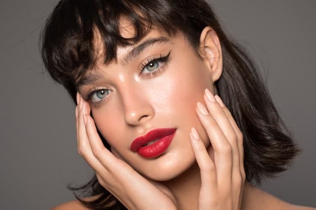 a close-up portrait of a beautiful dark-haired woman with red lipstick