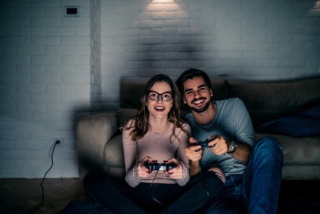a couple playing video games together in the evening