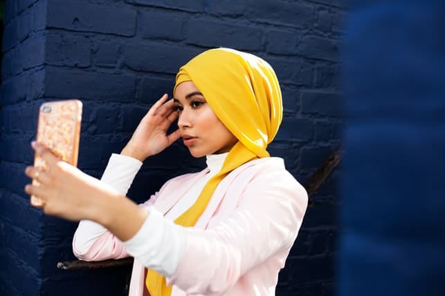 a modern muslim woman taking a selfie
