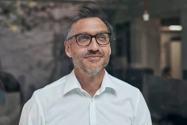 a mature man smiling and thinking