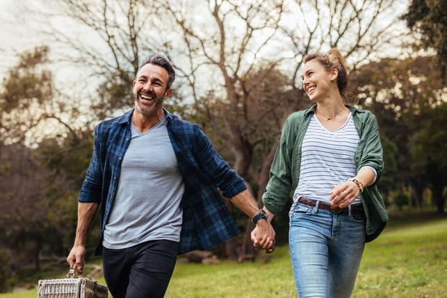 a couple walking through the park and having fun together