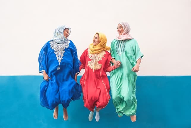 happy muslim women jumping together