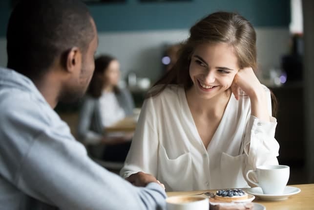 a woman is interested and smiles to a man in front of her