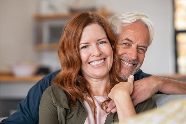 a portrait of a mature couple cuddling and posing at home