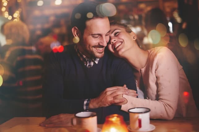 a couple hugging and enjoying each others company at a restaurant